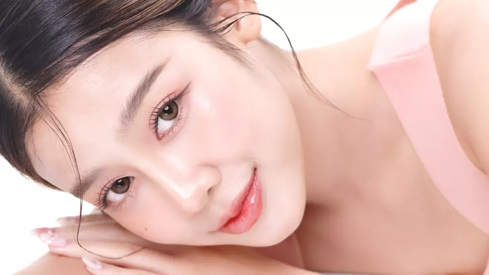 Młoda kobieta o zdrowej, promiennej skorze i makijażu zgodny z koreańskim k-beauty