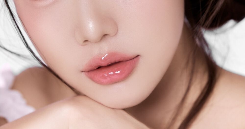 Zbliżenie na pokryte błyszczykiem usta młodej kobiety