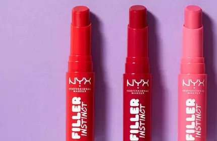 Trzy szminki NYX PM Filler Instinct na fioletowym tle.