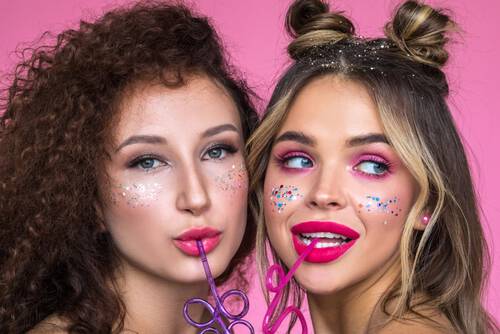 Dwie młode kobiety testują najnowsze trendy w makijażu przy pomocy rożnych kosmetykow