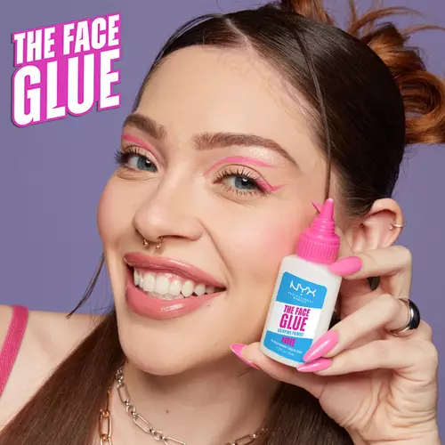 Młoda kobieta prezentuje buteleczkę bazy pod makijaż The Face Glue od NYX PM.