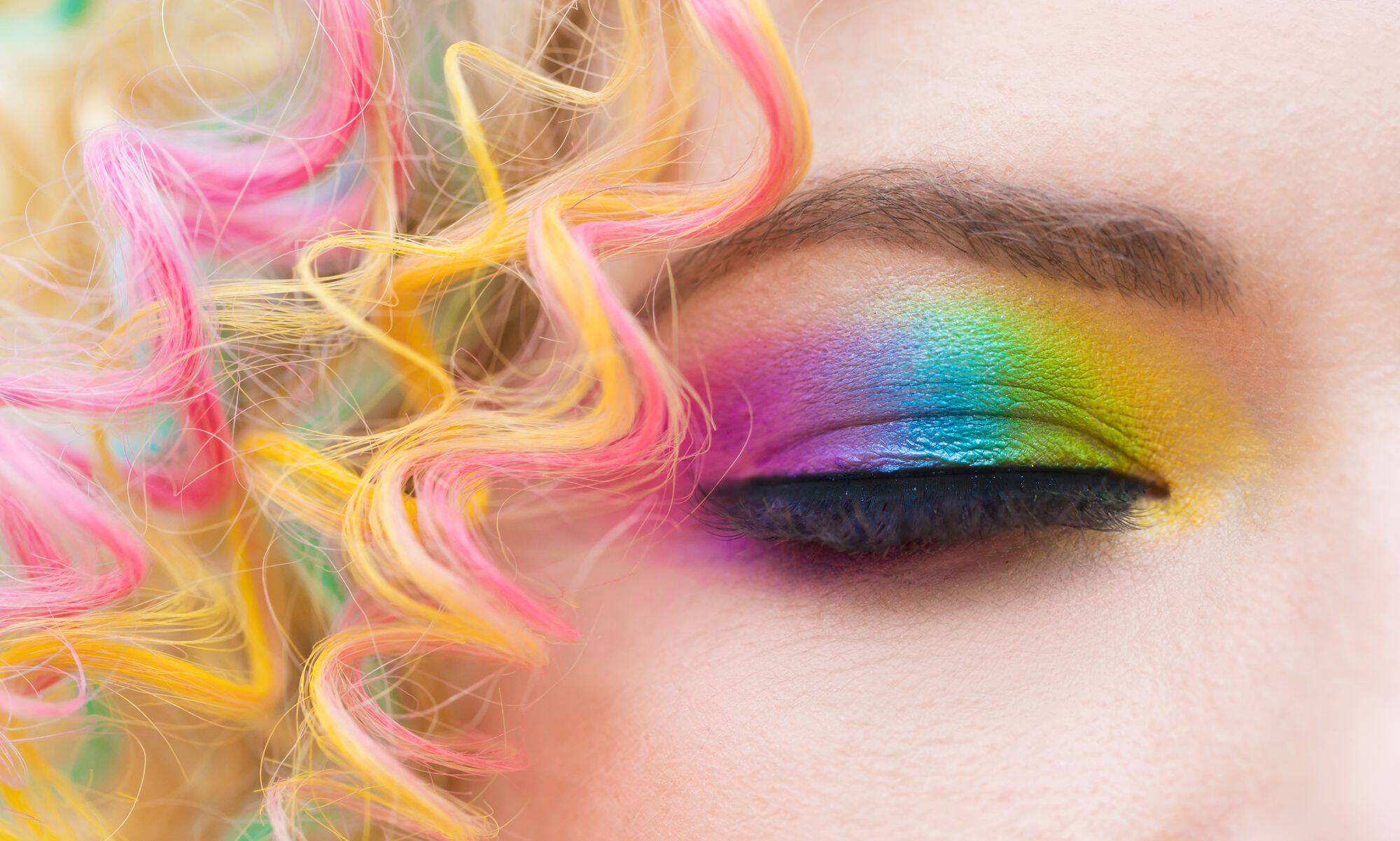 Zbliżenie na zamkniętą powiekę pokrytą cieniami, ktore tworzą na oku tęczę