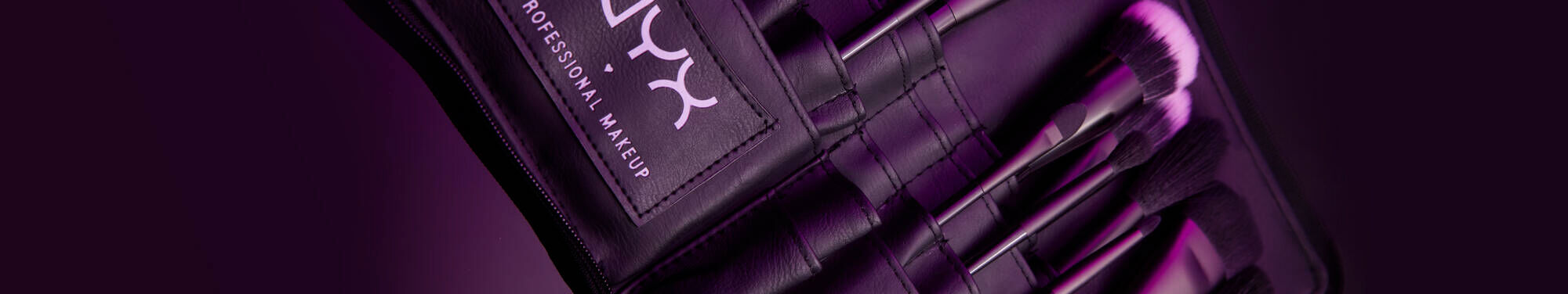 Fioletowe etui z pędzlami do makijażu marki NYX PM.