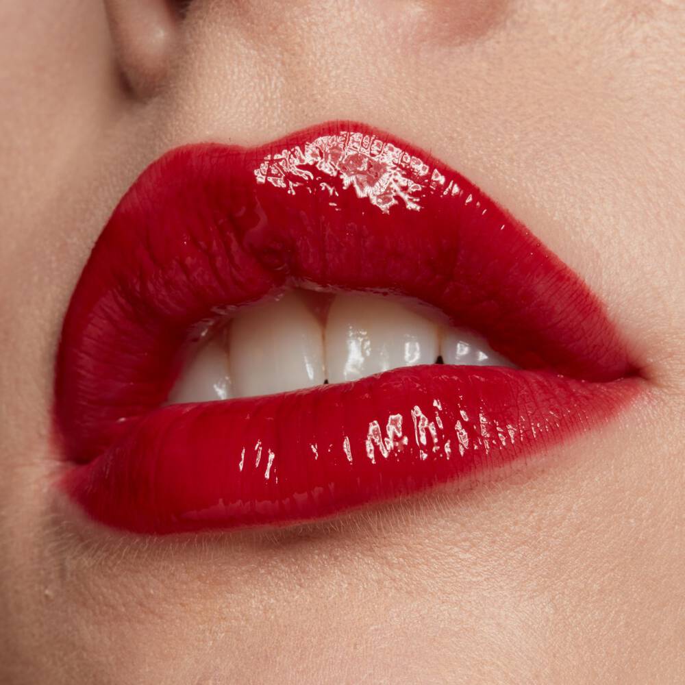 Usta kobiety pomalowane konturowką i błyszczącą czerwoną pomadką.