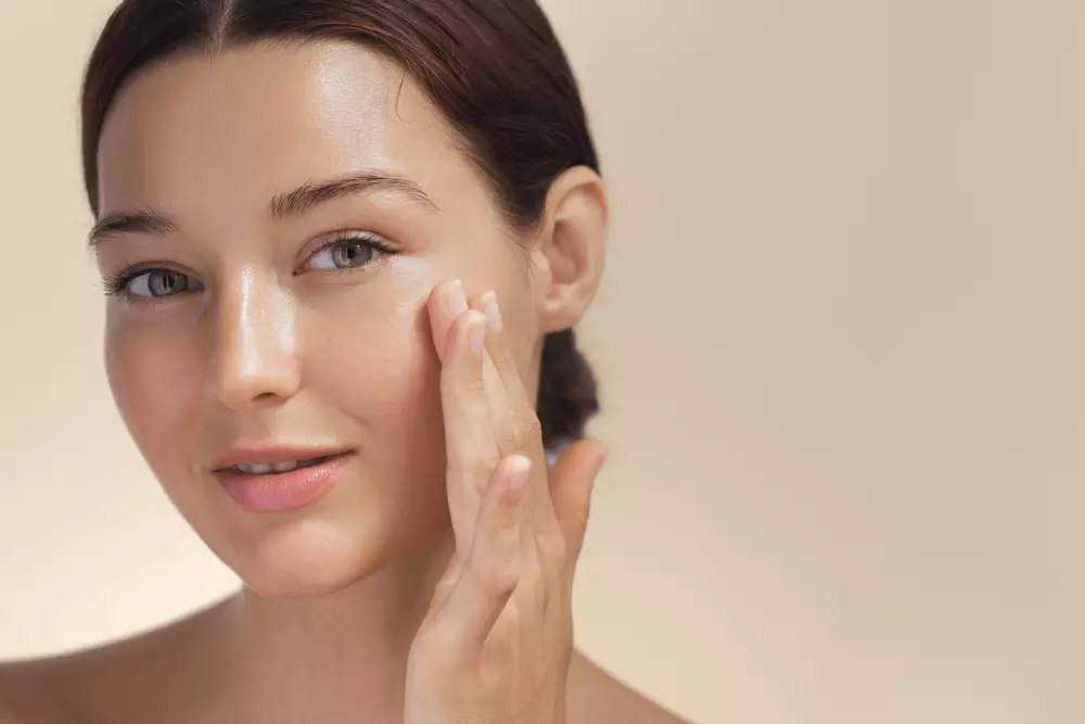 Młoda dziewczyna przed lustrem dotyka skory glass skin dzięki koreańskiej pielęgnacji