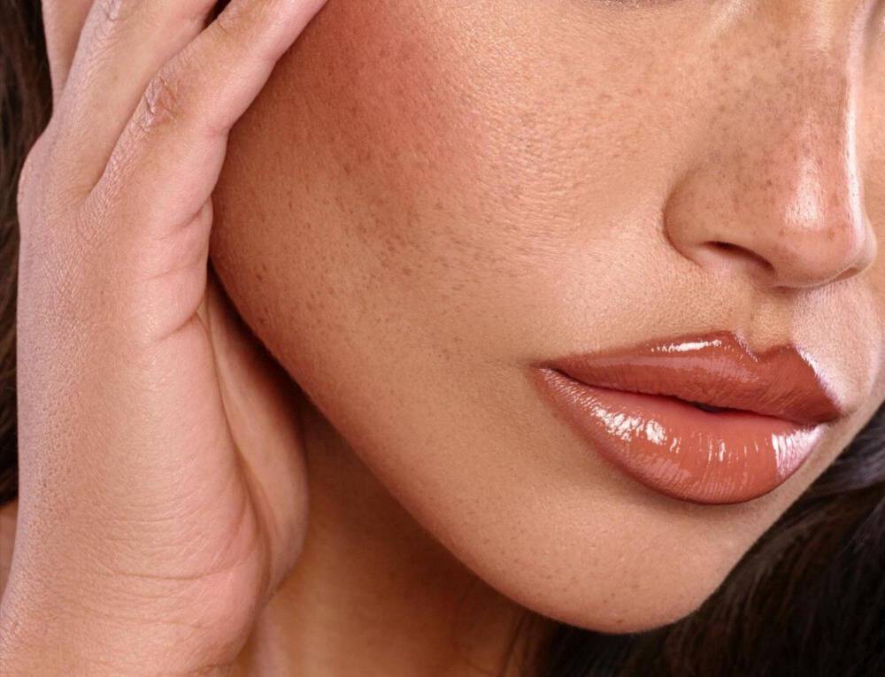 Modny makijaż ust w odcieniach brązu, z mocno zaznaczonym konturem oraz błyszczykiem