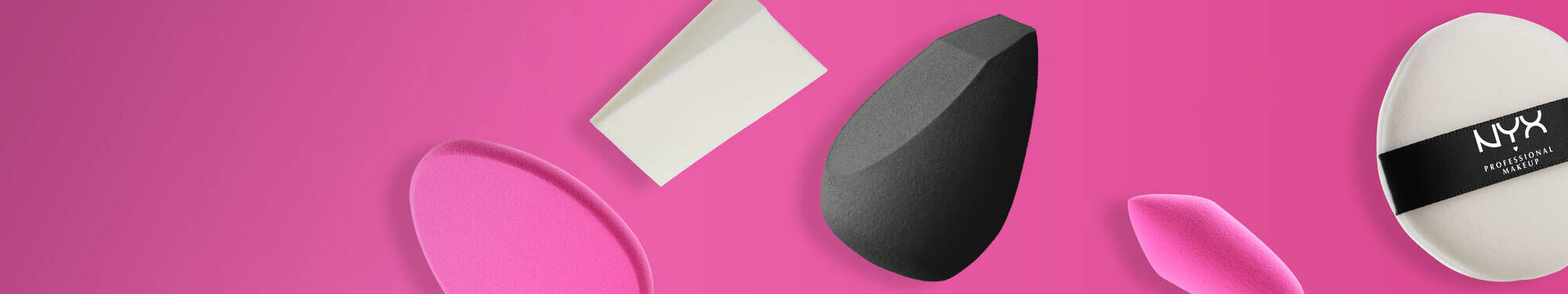 Rożne gąbki do makijażu na rożowym tle.