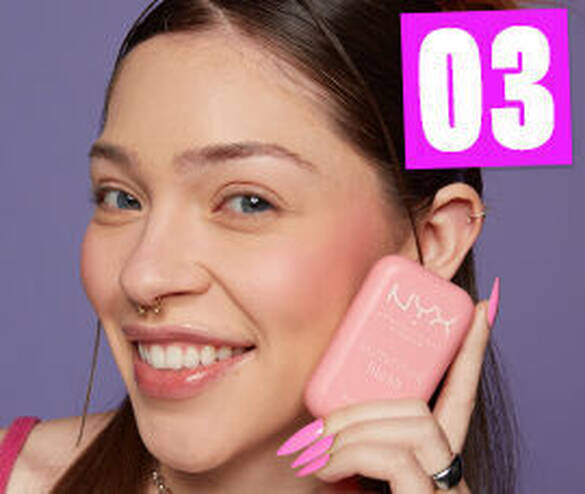 Młoda kobieta z rożowym kosmetykiem NYX, uśmiecha się, prezentując produkt na tle fioletowym. Numer 03 w rogu.