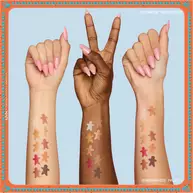 Trzy ramiona o rożnych odcieniach skory, z ktorych każde prezentuje swatche cieni do powiek z palety NYX Professional Makeup Holiday Gingerbaddie, ilustrując, jak kolory wyglądają na rożnych karnacjach.